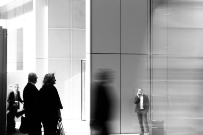 grayscale photo of people walking towards building